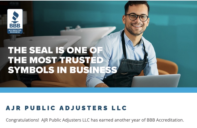 Smiling man in glasses and apron sitting at laptop with BBB Accredited Business seal and text highlighting trust in business accreditation. Announcement of AJR Public Adjusters LLC earning another year of BBB Accreditation